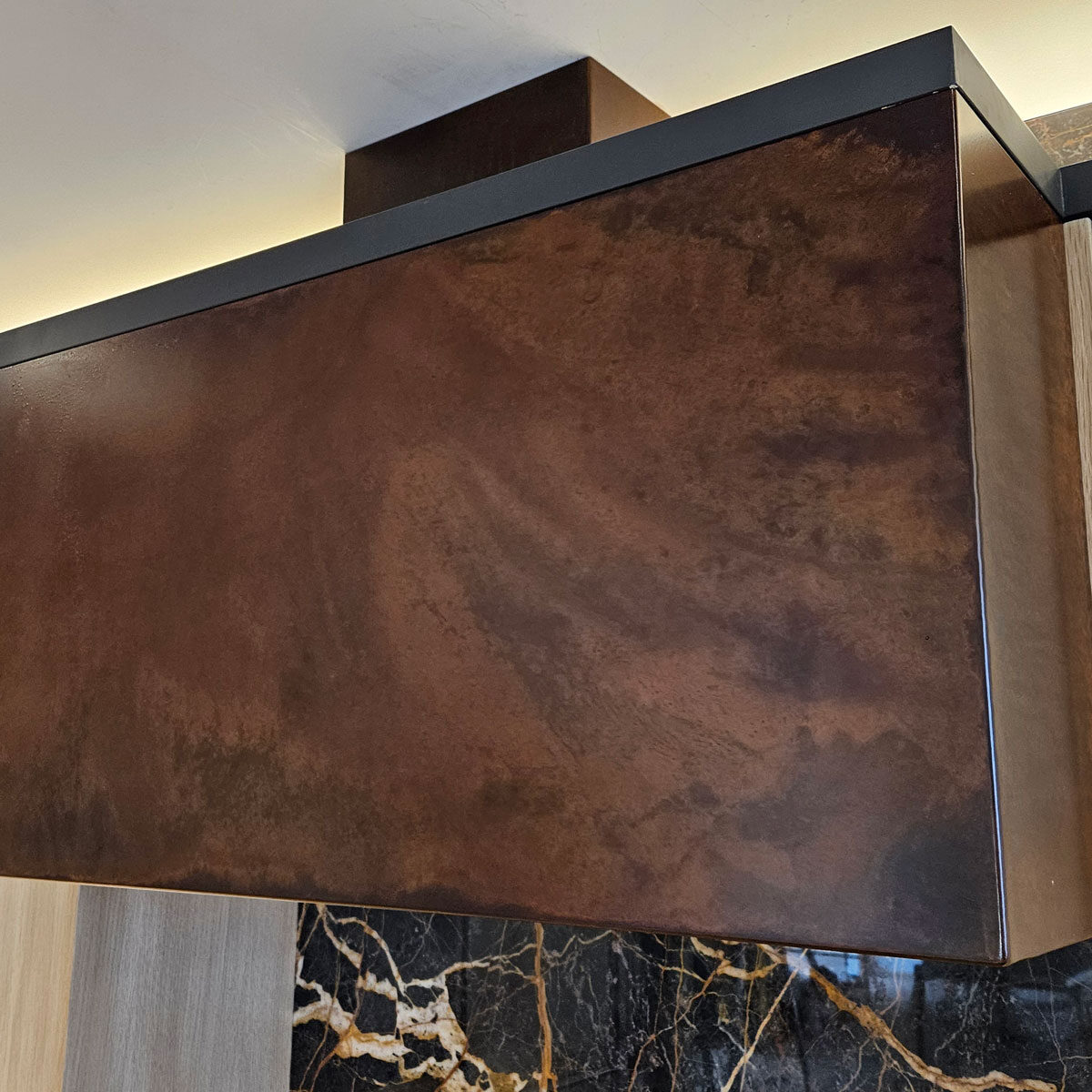 Hood range with artistic metal finish installed in home